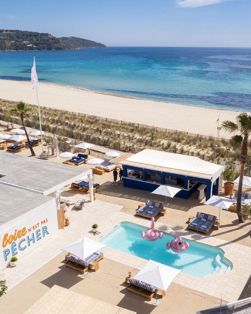Bagatelle Saint-Tropez garden terrace with tables set for lunch under greenery and pink blooms