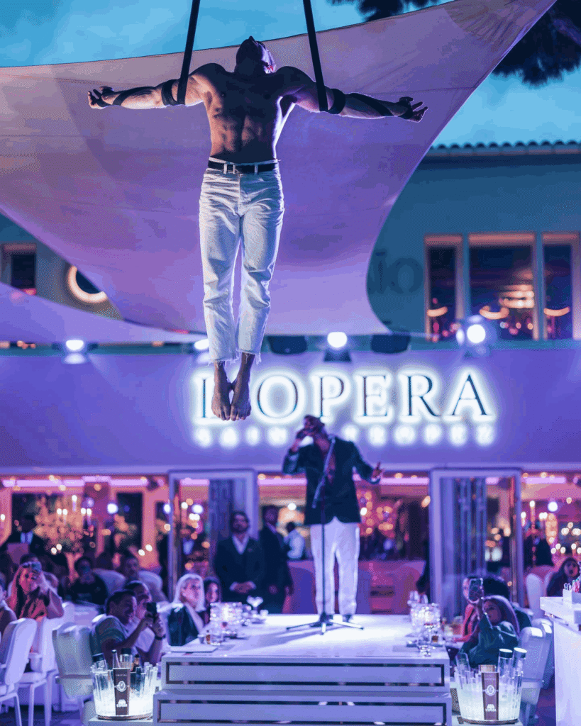 Aerial performer suspended above the entrance at La Opera Saint-Tropez