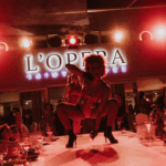 Cabaret performer entertaining guests on stage at La Opera Saint-Tropez