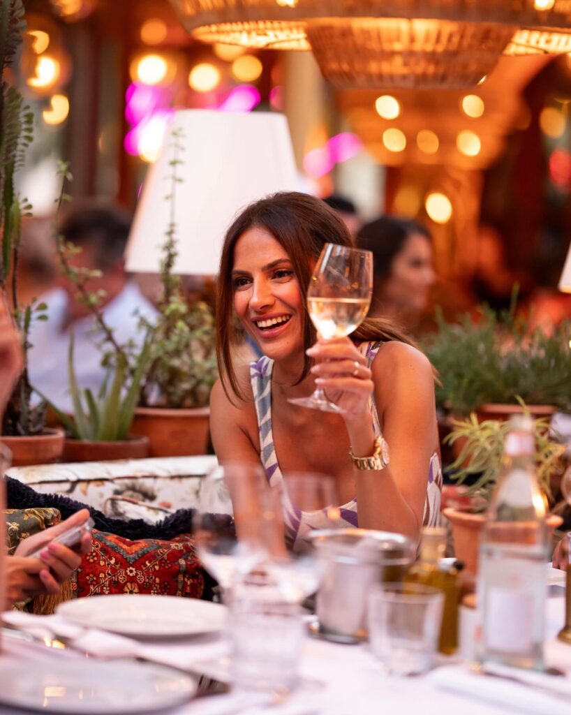 Guest making a champagne toast at Le Café Saint-Tropez