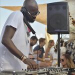 DJ playing a daytime set at Verde Beach as guests enjoy the beach club