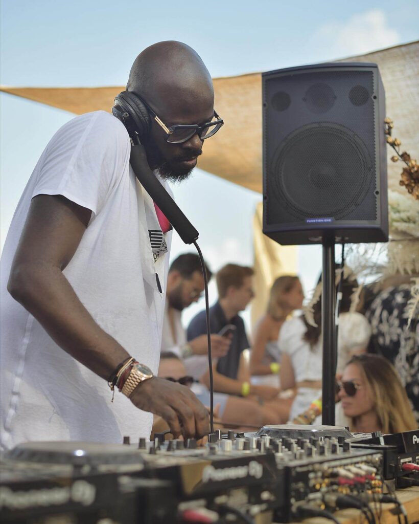 DJ playing a daytime set at Verde Beach as guests enjoy the beach club