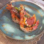 Grilled prawns with citrus and herbs plated on ceramic at Verde Beach