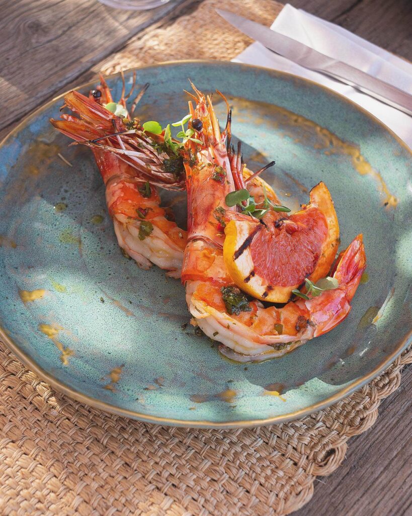 Grilled prawns with citrus and herbs plated on ceramic at Verde Beach