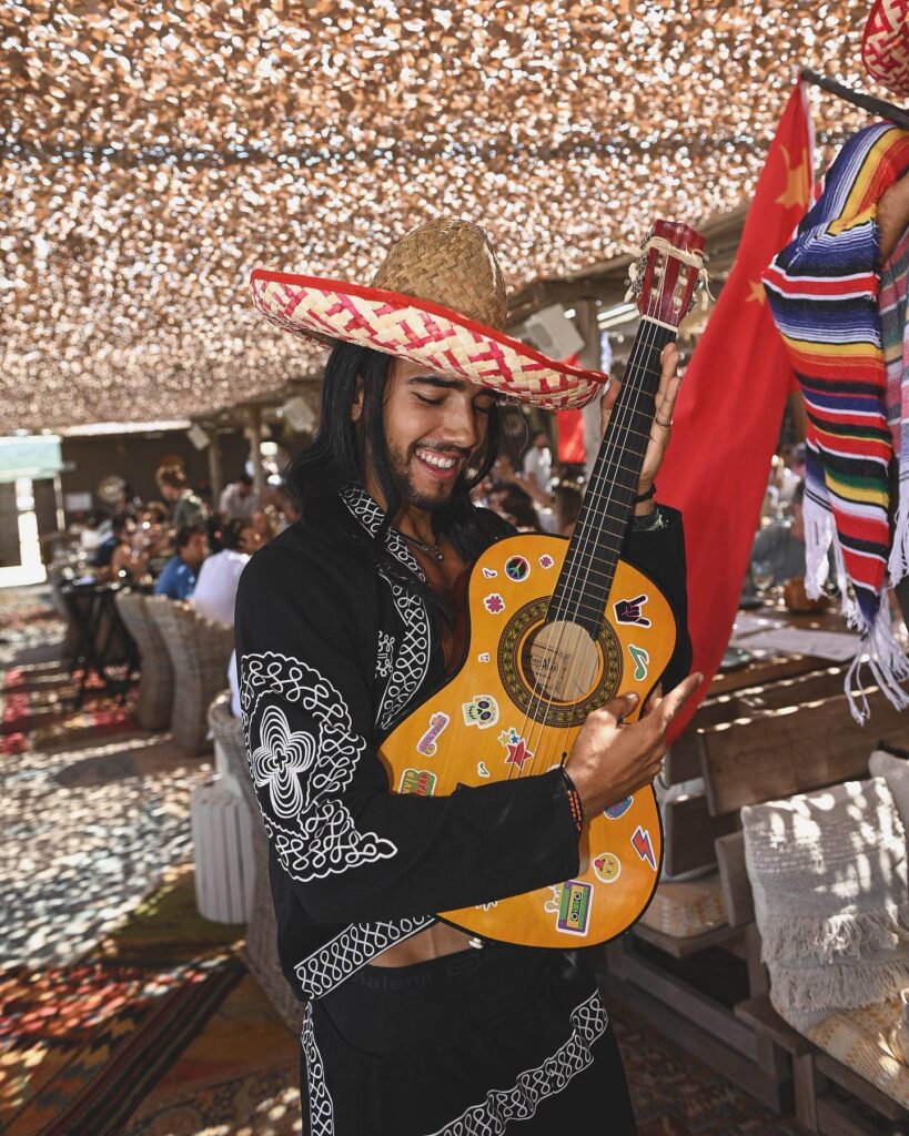 Mariachi performer with guitar entertaining guests at Verde Beach