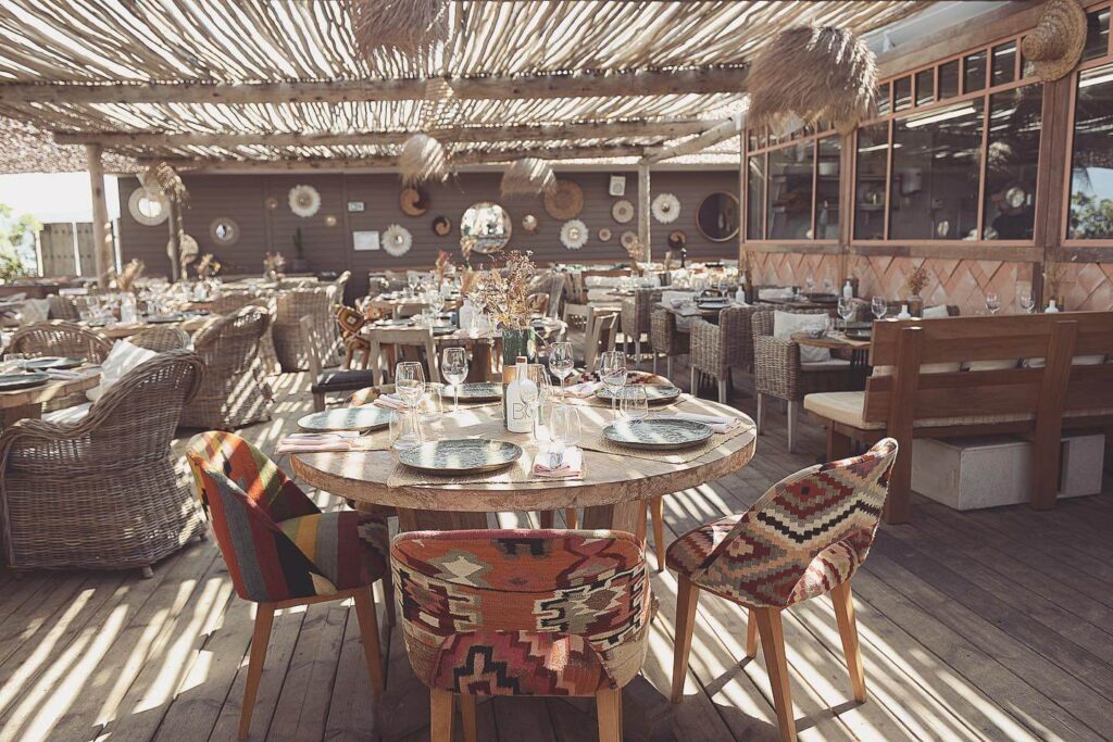 Verde Beach dining room with round tables and patterned kilim chairs