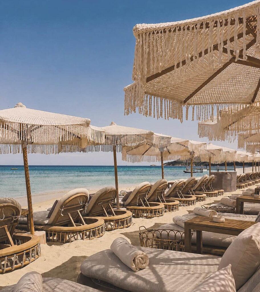 Verde Beach sunbeds and fringed parasols lined along the shore with a clear sea view
