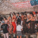 Guests dancing on the tables during an afternoon party at Verde Beach