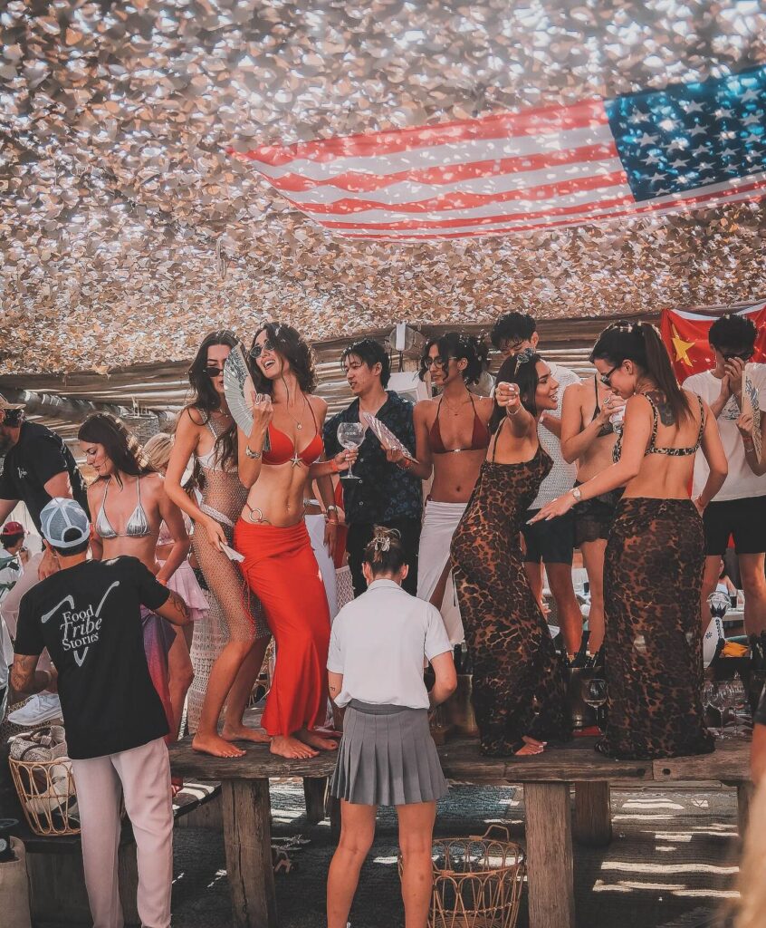 Guests dancing on the tables during an afternoon party at Verde Beach