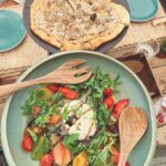 Truffle pizza and burrata salad with heirloom tomatoes and rocket served at Verde Beach