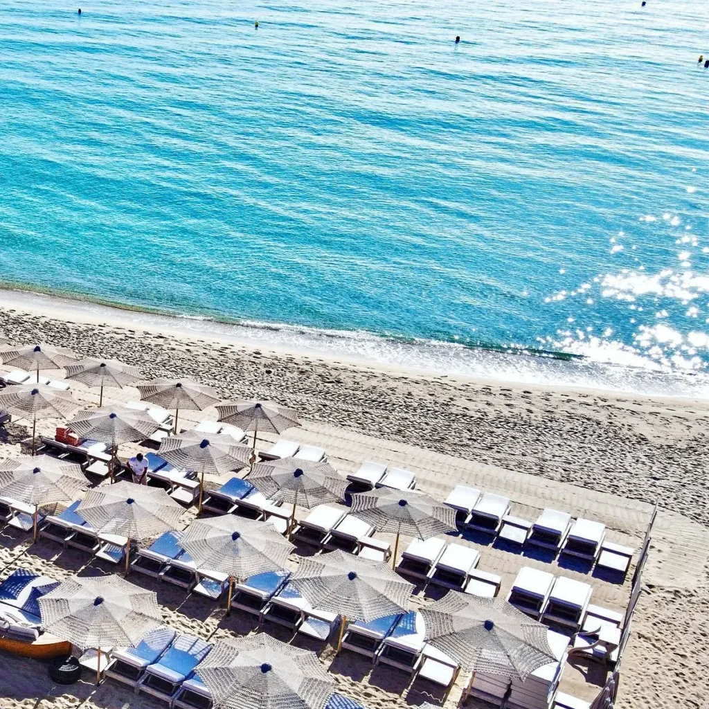 Overhead view of sunbeds and turquoise sea at Byblos Beach Ramatuelle