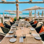 Set dining table overlooking the beach and sea at Byblos Beach Ramatuelle