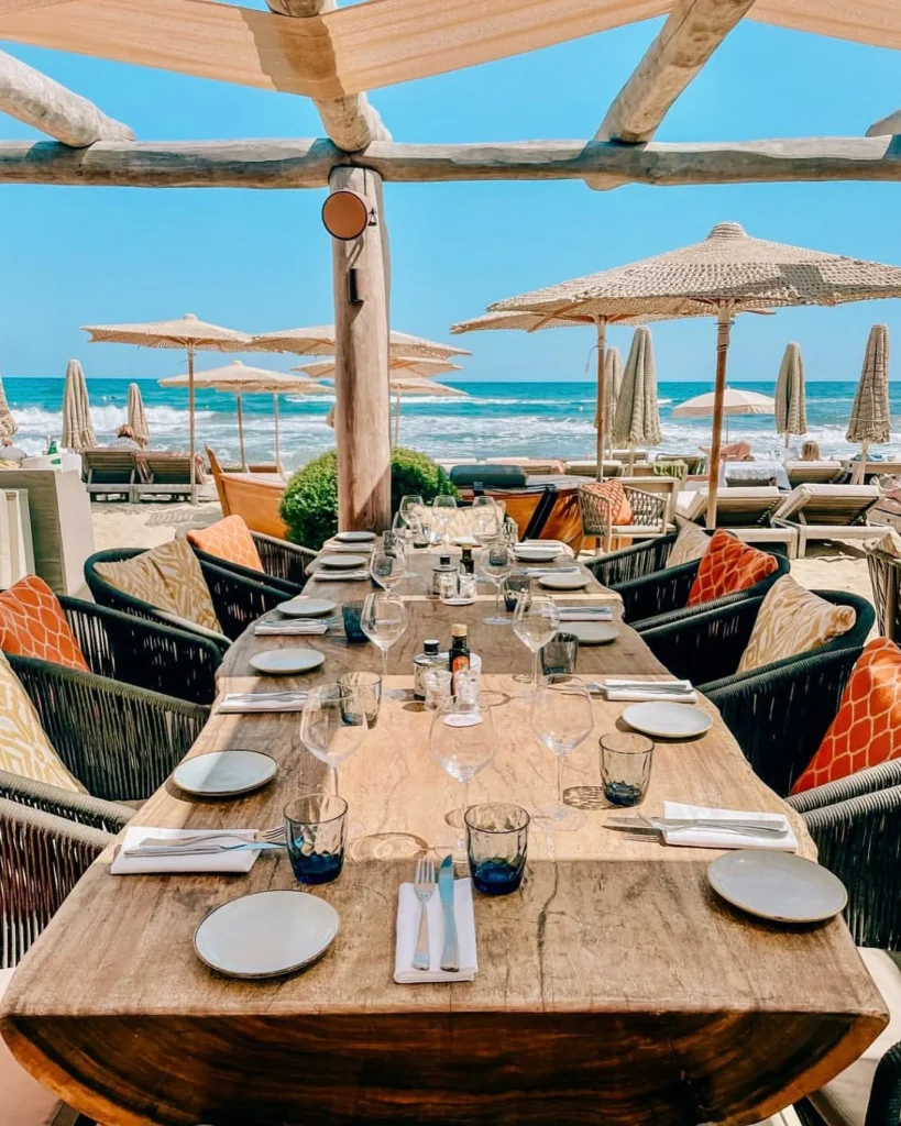 Set dining table overlooking the beach and sea at Byblos Beach Ramatuelle