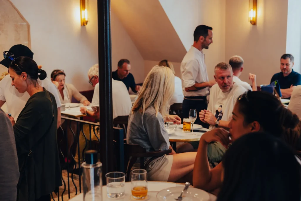 Busy dining room full of guests with a waiter taking an order at El Caminito Palma