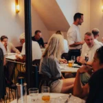 Busy dining room full of guests with a waiter taking an order at El Caminito Palma