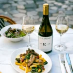 Lamb chops with fries, salad and house wine on a terrace table over cobblestones at El Caminito Palma
