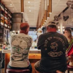 Two guests on burgundy stools at the counter seen from behind at El Camino Restaurant