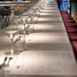 Marble counter set with menus, glassware and burgundy stools at El Camino Restaurant