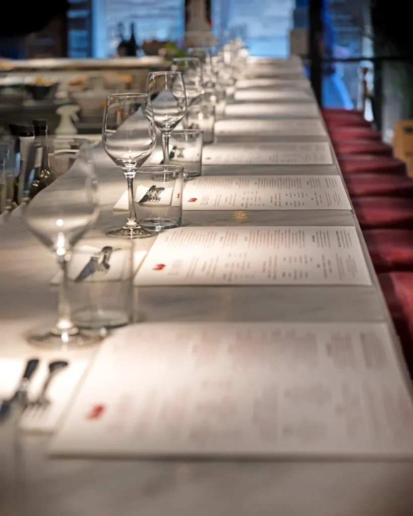 Marble counter set with menus, glassware and burgundy stools at El Camino Restaurant