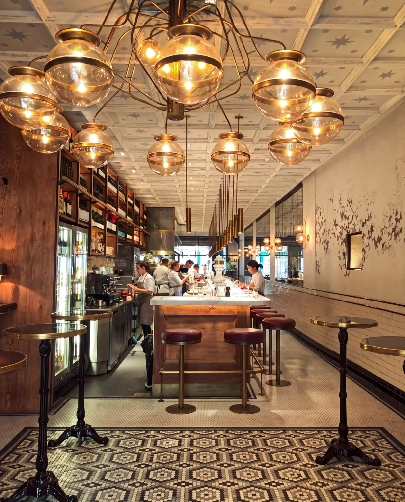 Interior with a brass globe chandelier over the open kitchen counter and mosaic floor at El Camino Restaurant