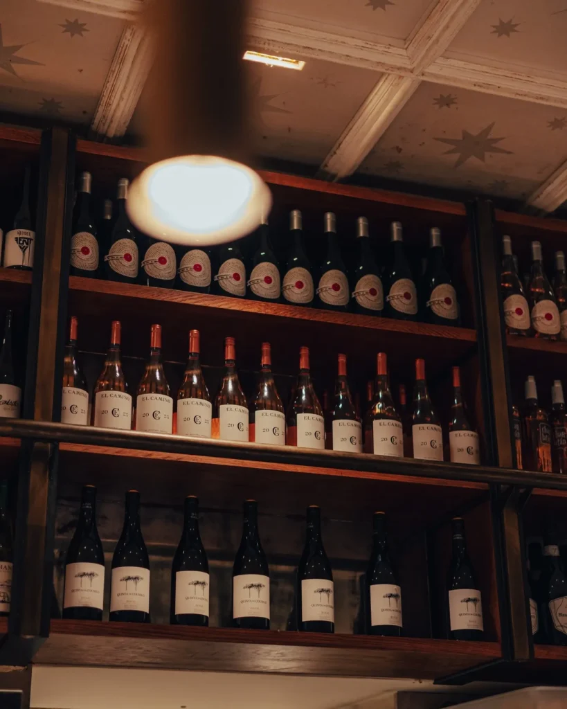 Shelves of house El Camino and other wine bottles below a star-panelled ceiling at El Camino Restaurant