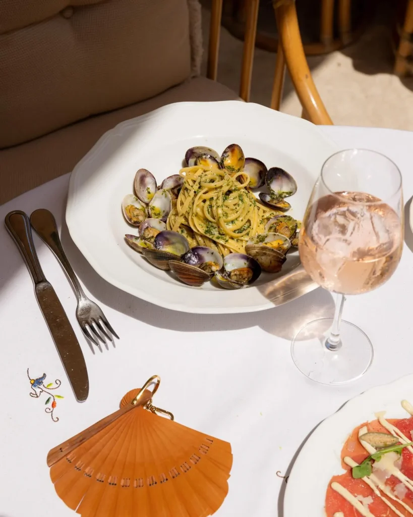 Linguine with clams and herbs beside a glass of rosé at Gigi Rigolatto Paris