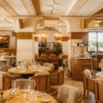 Art Deco dining room with onyx tables, cane armchairs and rattan pendants at Gigi Rigolatto Paris