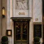 Marble facade with gold GIGI lettering above green-and-brass doors at Gigi Rigolatto Paris