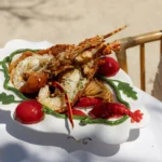 Lobster over pasta on a vegetable-motif platter in bright sunlight at Gigi Rigolatto Paris
