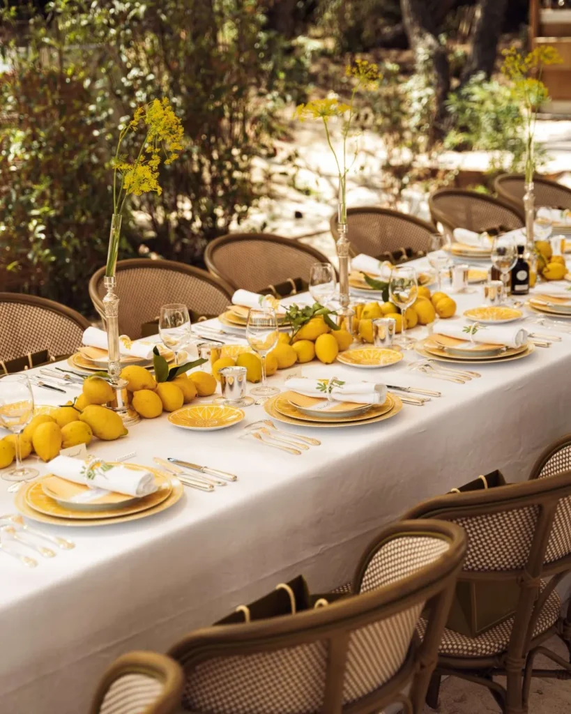 Long table dressed with lemons, silver and yellow flowers in the garden at Gigi Rigolatto Saint-Tropez