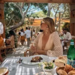 Guest with wine over a steak and salad lunch beneath the pergola at Gigi Rigolatto Saint-Tropez