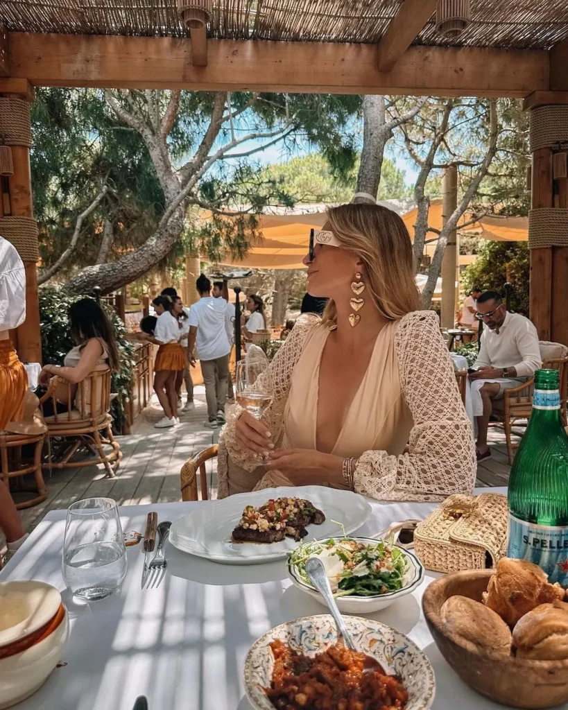 Guest with wine over a steak and salad lunch beneath the pergola at Gigi Rigolatto Saint-Tropez
