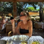 Guest sipping rosé over a sea bass lunch under the pergola at Gigi Rigolatto Saint-Tropez