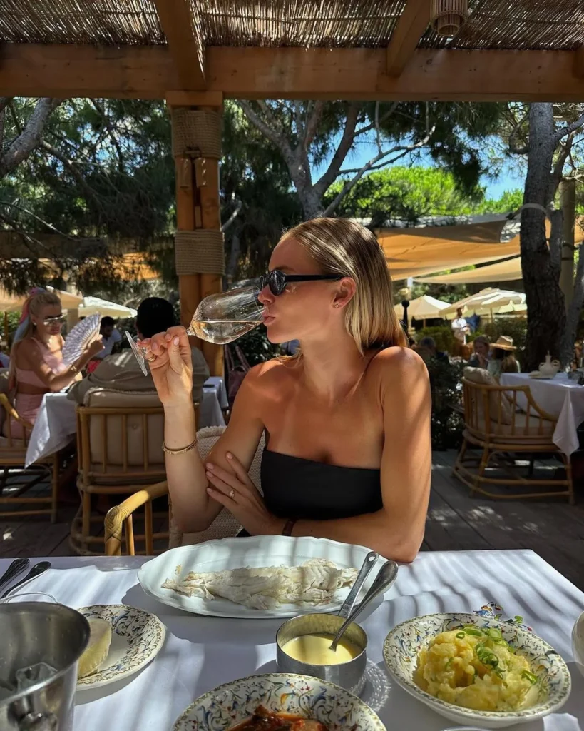 Guest sipping rosé over a sea bass lunch under the pergola at Gigi Rigolatto Saint-Tropez