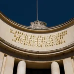 Curved Palais de Tokyo facade with the gold Paul Valéry inscription and a stone sculpture at Girafe Paris
