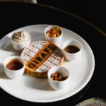 Waffle branded GIRAFE with cream and dipping sauces on a white plate at Girafe Paris