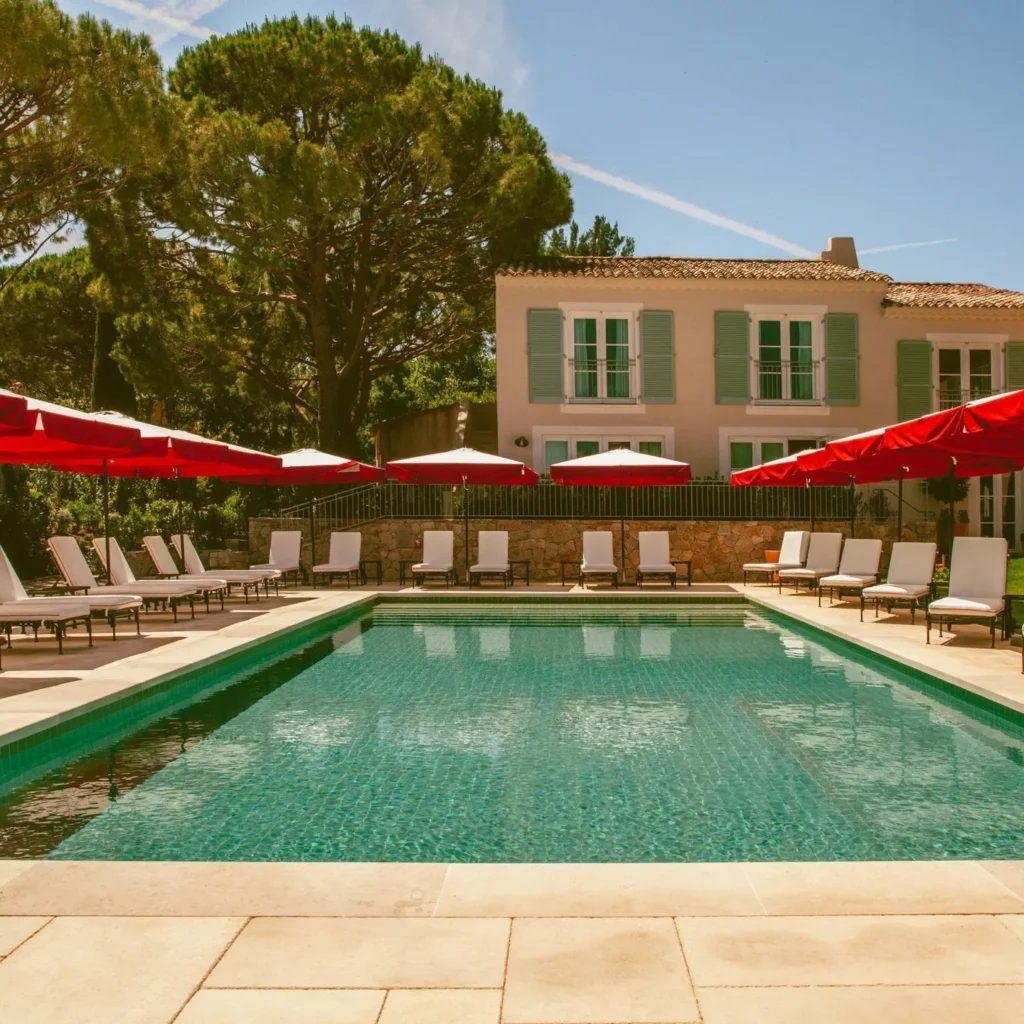 Swimming pool with red umbrellas at Hôtel Lou Pinet Saint-Tropez