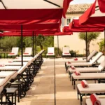 Pool terrace with red umbrellas at Hôtel Lou Pinet Saint-Tropez
