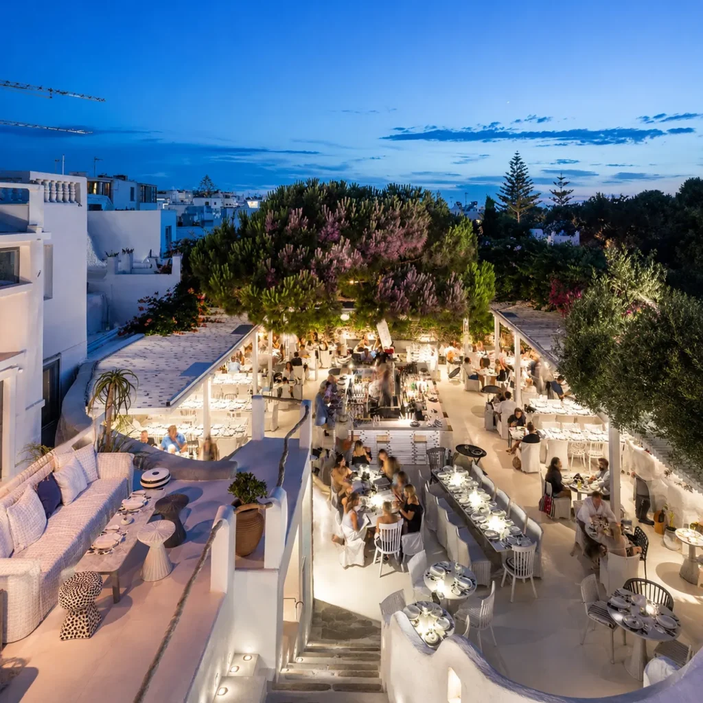 Aerial view of the whitewashed terraces full of diners at dusk at Interni Restaurant Mykonos