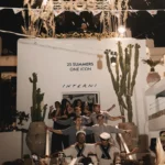 Staff posing with sparklers under the MOS sign and a 25 Summers One Icon wall at Interni Restaurant Mykonos