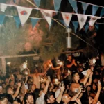 Guests celebrating with sparklers under evil-eye bunting at night at Interni Restaurant Mykonos