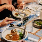 Seared scallops in sauce with broccolini as guests dine at Interni Restaurant Mykonos