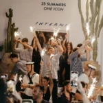 Team raising sparklers before the 25 Summers One Icon wall at Interni Restaurant Mykonos