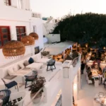 White terraces with rattan pendant lights and set tables at twilight at Interni Restaurant Mykonos