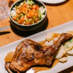Confit duck leg with sliced potatoes and a side salad at La Bodeguilla Palma