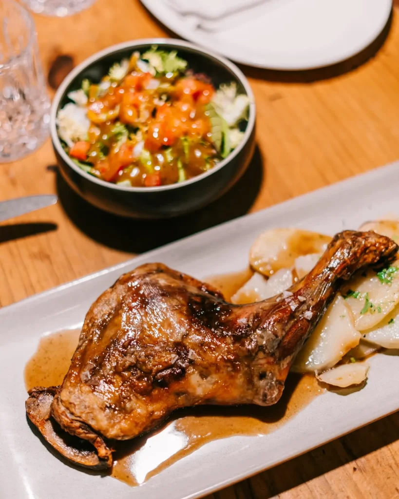 Confit duck leg with sliced potatoes and a side salad at La Bodeguilla Palma