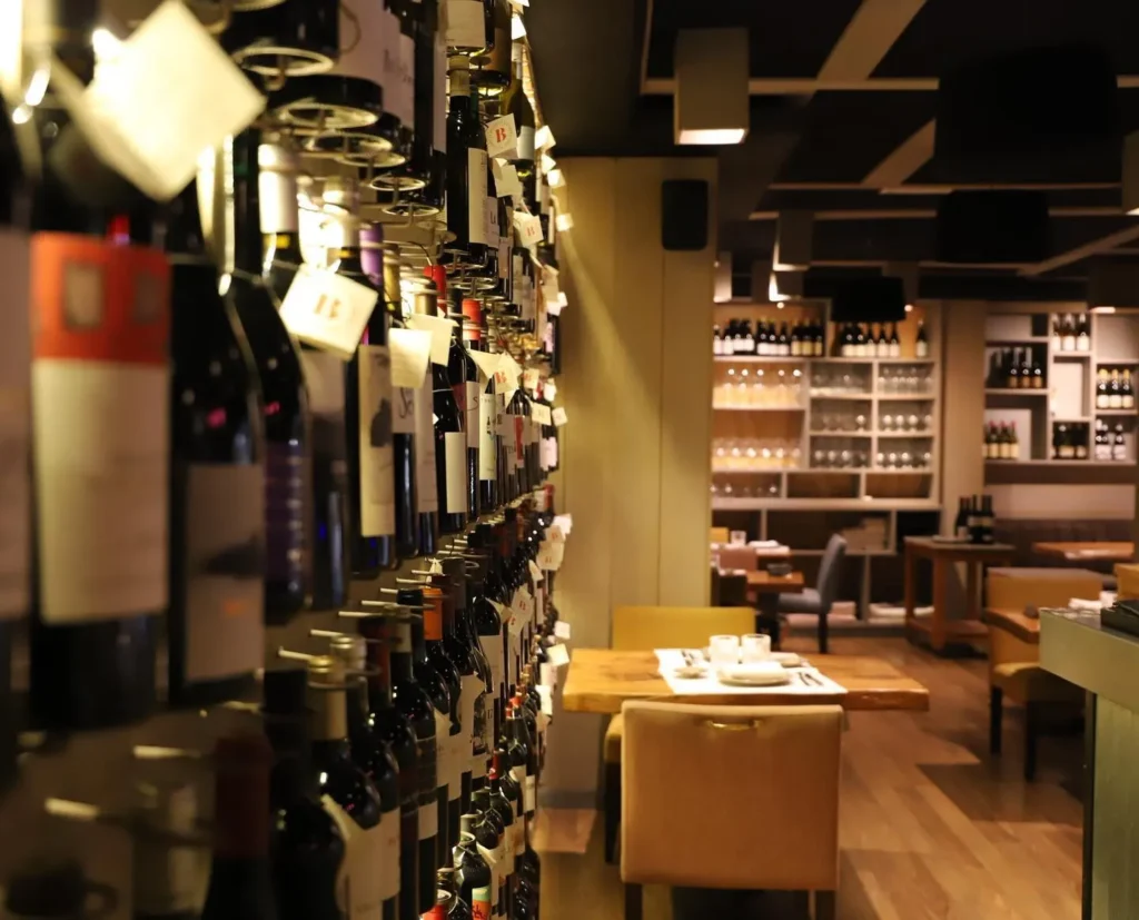 Dining tables beyond a wall of tagged wine bottles at La Bodeguilla Palma