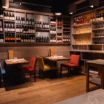 Set tables with red and yellow chairs before a shelved wine wall at La Bodeguilla Palma