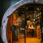 Barrel-ring arch entrance with a Michelin sticker looking into the wine-lined interior at La Bodeguilla Palma