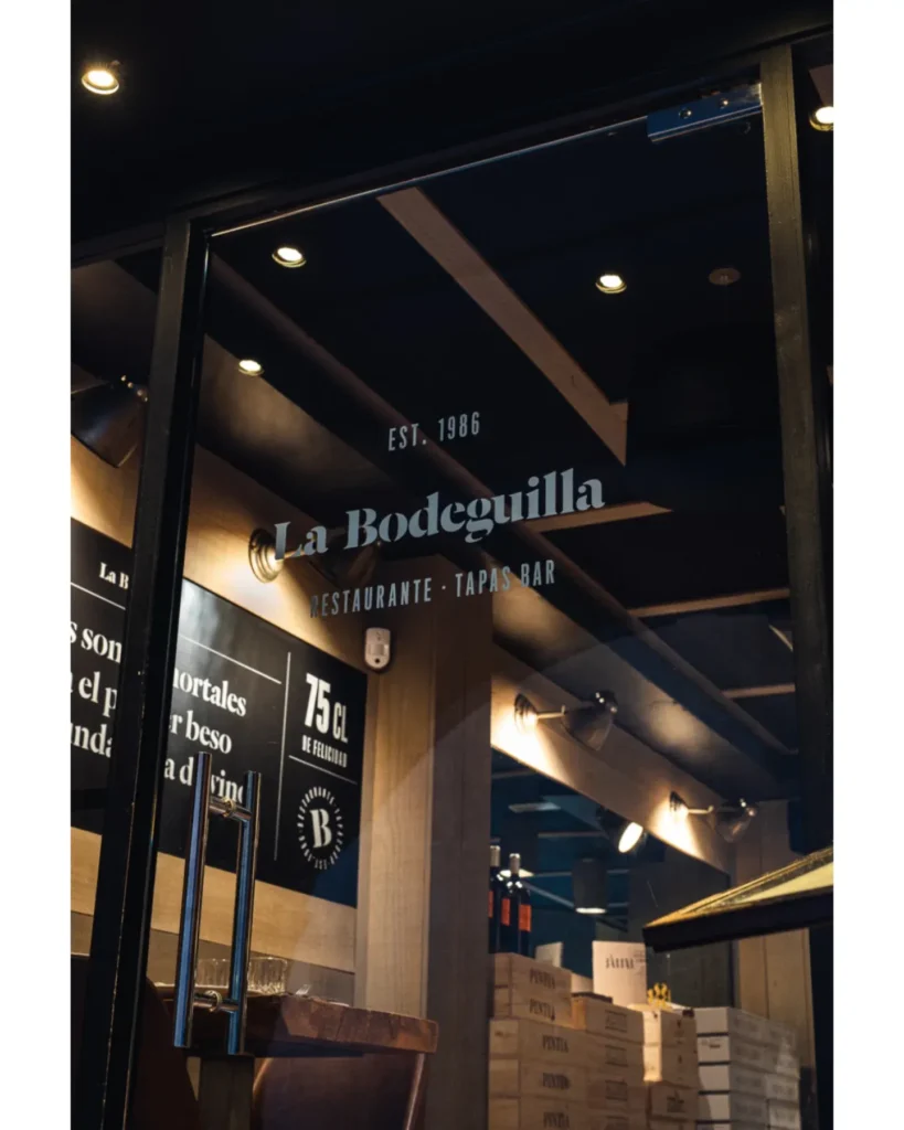Glass door etched with the La Bodeguilla est. 1986 restaurant and tapas bar logo at La Bodeguilla Palma